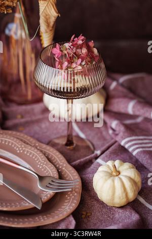 Elegant fall dining setup with rustic tableware and pumpkins Stock Photo