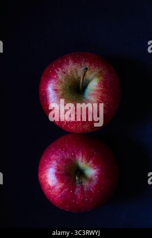Two Vibrant Red Apples From Above on a Dark Elegant Background Stock Photo