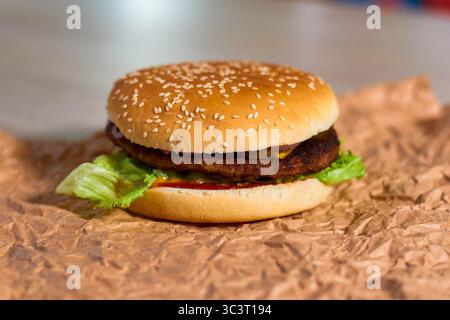 juicy burger with beef cutlets. The juicy beef cutlet with the grill, the molten cheese of Chedder, the crunchy bacon, pickled cucumbers and sauce in Stock Photo