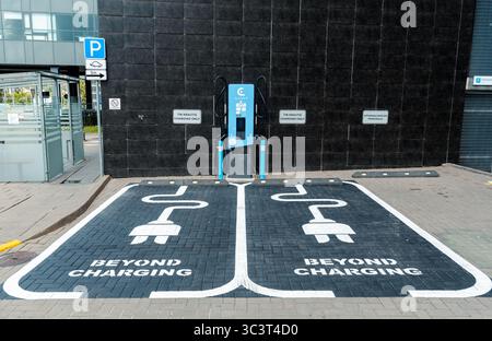 Charging stations and parking spots in a designated parking area with clear markings and signage, Green energy and transport concept Stock Photo