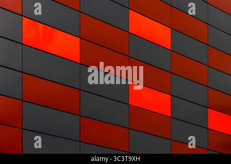 Office building facade with geometric red and black metal cladding pattern Stock Photo