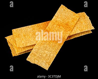 Long chips isolated on black background, rectangular potato snacks, package design element Stock Photo