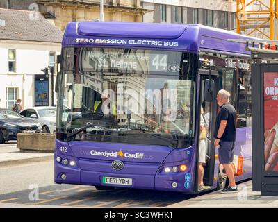 Cardiff, wales, UK - 16 July 2025: Passengers boarding an electric public service bus in Cardiff city centre. The service is operated by Cardiff Bus. Stock Photo