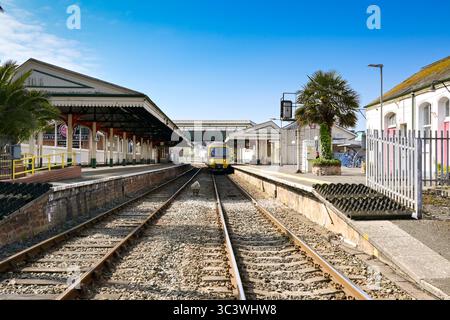 Paignton, Devon, England, UK - 24 April 2025: Wide angle view of Paignton railway station with a commuter train at the platform Stock Photo