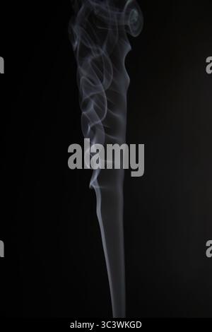 Abstract figure created by white smoke on an isolated black background to stimulate the subconscious with truly beautiful shapes Stock Photo