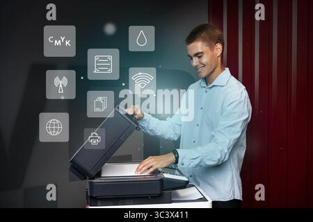 Man operates modern printer in an office setting showcasing various functions during the day Stock Photo