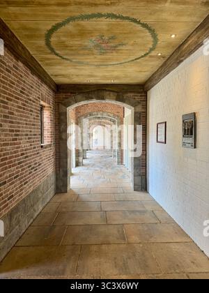 Elegant arched brick corridor at Hansa Park, Germany, featuring a painted ceiling and patterned stone floor. The symmetrical arches and light create a Stock Photo