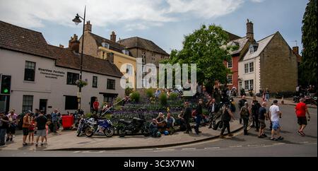 A lively street scene in the quaint town of Calne with people gathered around motorcycles on a sunny day at the annual bike meet July 2025 Stock Photo