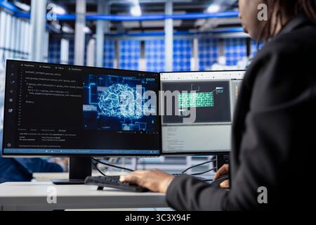 Technician building artificial intelligence solutions in solar panel factory, applying machine learning algorithms to predict errors and automatically adjust production processes Stock Photo