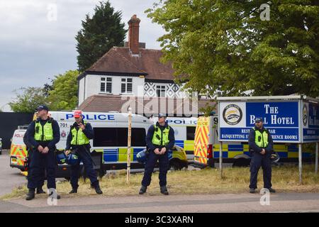 Epping, UK. 27th July, 2025. Police officers guard the Bell Hotel in Epping as both pro- and anti- migrant protesters gather outside. Several anti-migrant protests targeting the Bell Hotel, where migrants are housed, have taken place after an asylum seeker was charged with allegedly trying to kiss a 14-year-old girl. Credit: SOPA Images Limited/Alamy Live News Stock Photo