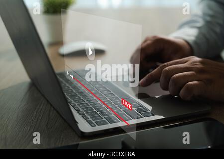 An ott sharing video streaming person using laptop with holographic live streaming interface projecting above keyboard, creating futuristic Stock Photo