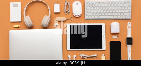 Many different modern gadgets on orange background Stock Photo