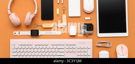 Many different modern gadgets on orange background Stock Photo