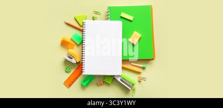 Composition with notebooks and different school stationery on green background Stock Photo
