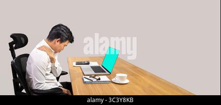 Overworked male office worker suffering from neck pain after had a long day at work. Stock Photo