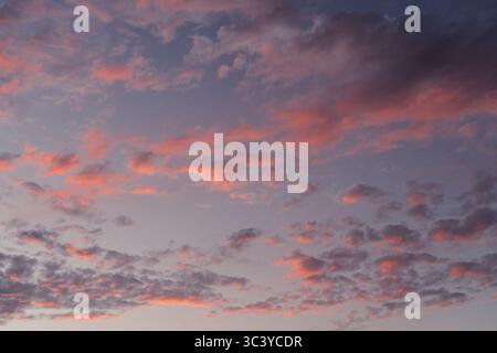 Radiant Sunset Sky with Swirling Cloud Formations Stock Photo