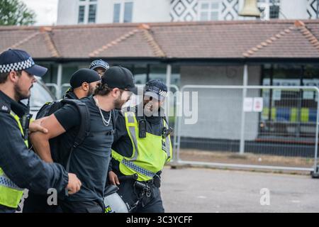 London, UK. 27th July, 2025. An anti-migrant protestor is temporarily detained and searched for weapons by the Police outside the Bell Hotel in Epping. Thousands of anti-far-right counter-protestors marched to Bell Hotel in Epping to oppose the anti-migrant demonstrators rallying outside the hotel for the third weekend in a row. A huge police presence kept the two opposing groups separated by penning the anti-migrant demonstrators in behind fences. (Photo by Lab Ky Mo/SOPA Images/Sipa USA) Credit: Sipa USA/Alamy Live News Stock Photo