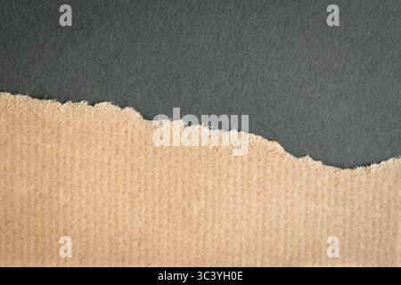Brown cardboard ripped paper torn edges on dark gray background. Copy space. Stock Photo