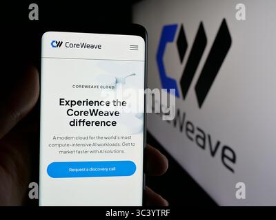 Stuttgart, Germany - 06-07-2025: Person holding cellphone with webpage of US AI cloud computing company CoreWeave Inc. on screen in front of logo. Stock Photo