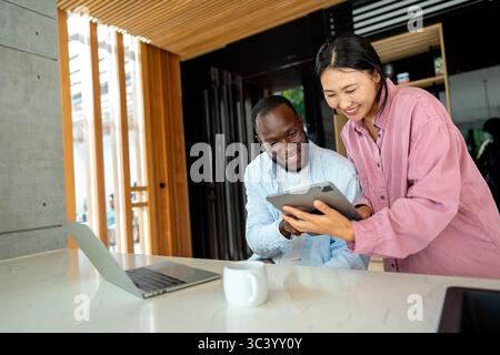 Multicultural couple working remotely, planning finances and investments online. Digital lifestyle Stock Photo