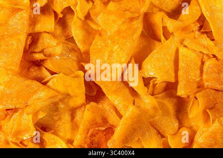 Top view pile of sweet crispy potato chips on the table, closeup background. Stock Photo