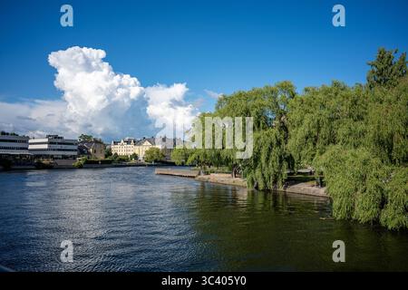 Cumulus clowds above Motala Stream in Norrköping during a summer evening. Norrköping is a historic industrial town in Sweden. Stock Photo