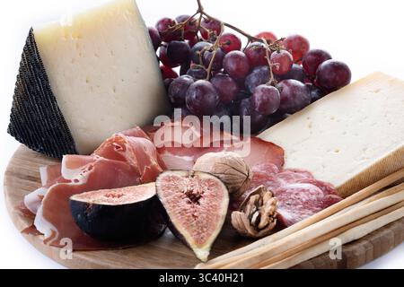 Charcuterie Board with Cheese, Grapes, Figs and wine isolated on white background Stock Photo
