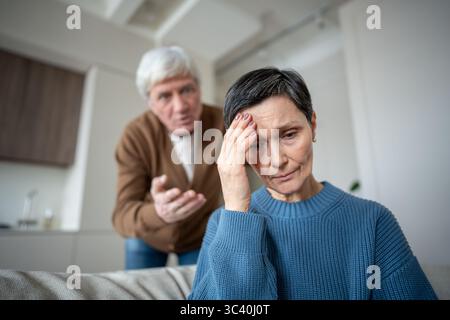 Elderly couple in conflict, man blaming wife remains frail and fearful, narcissistic husband Stock Photo