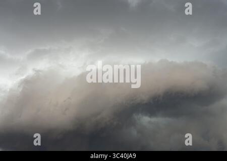 Below dark discoloured storm clouds Cloud roll above grey clouds Rain clouds heralding thunderstorms, Germany Stock Photo