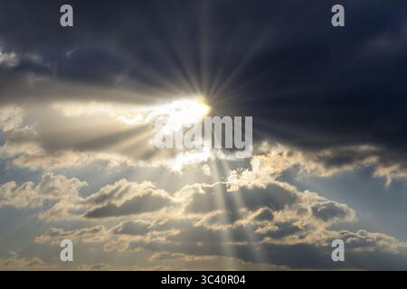 Dramatic rays of sunshine break through dark clouds in the sky, Baden-Wuerttemberg, Germany Stock Photo