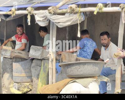 Group of men working in a gold panning workshop, some smiling, Howrah, Kolkata, West Bengal, India Stock Photo