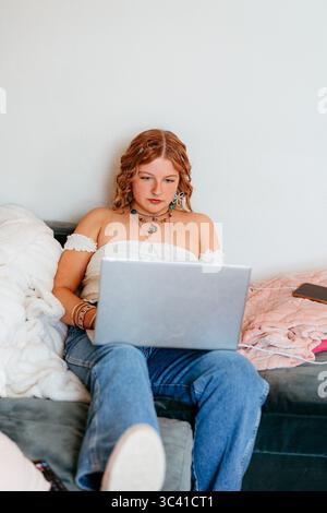 Young college student working on laptop at home Stock Photo