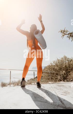Woman in Orange Sportswear Celebrates a Workout Stock Photo