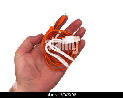 USA type C, USB type A, micro usb, chargers, type c, white usb, orange usb. A hand holding two different colored cords. One is white and the other is Stock Photo