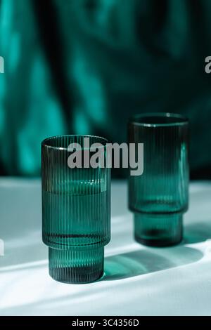 Dual Transparent Ribbed Glasses on White Table Stock Photo
