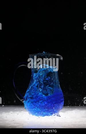 Water explosion in water vessel, blue with water carpet Stock Photo