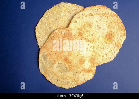 Flatbread crackers with seeds on a blue background Stock Photo