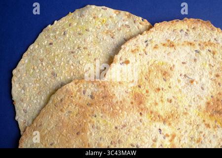 Flatbread crackers with seeds on a blue background Stock Photo