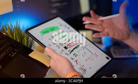 graphic tablet Project Chaos Frustration To Do List Overload visualized by messy notes on digital tablet. Developer reacting to excessive corrections, Stock Photo