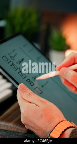 Checklist Organization Workspace Productivity Concept. Close-up of a person reviewing a handwritten to-do list in a notebook, set on a modern desk wit Stock Photo