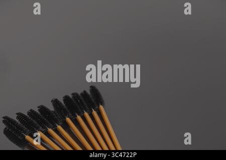 Set of eyelash brushes on a black background. Professional disposable mascara wands for eyelash extension, makeup and beauty salon use. Stock Photo