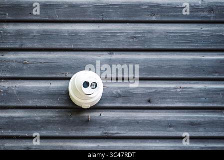 Security camera on a wooden wall. Surveillance and protection concept. Stock Photo