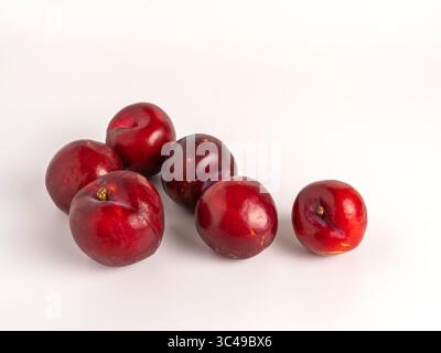 Ripe red plums isolated on white background, fresh, juicy, healthy, and organic. Stock Photo