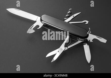 Multifunction army pocket folding knife isolated on black background Stock Photo