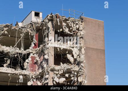 Partially demolished building with exposed concrete and rebar against a clear blue sky. Urban decay and demolition in progress. Utrecht, Holland. Stock Photo