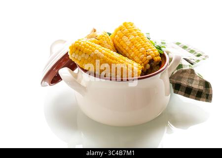 Two boiled corn cobs with dill on a white background. Stock Photo
