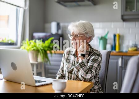 Senior woman using laptop at home Stock Photo