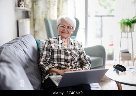 Senior woman using laptop at home Stock Photo