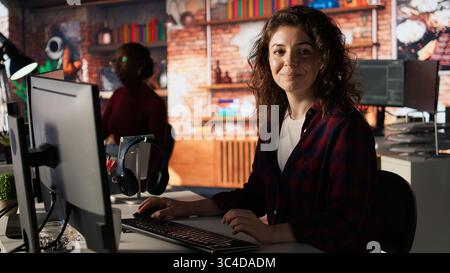 Portrait of upbeat programmer coding advanced AI algorithm in startup, refining machine learning models to enhance automation. Cheerful woman using coding platform in Silicon Valley office, camera A Stock Photo