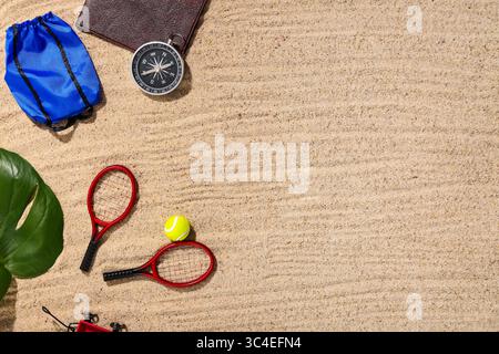 Passport with compass and toys on sand, top view Stock Photo